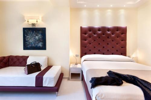 a hotel room with two beds and a couch at Palazzo Tritone & Abagnale in Sorrento