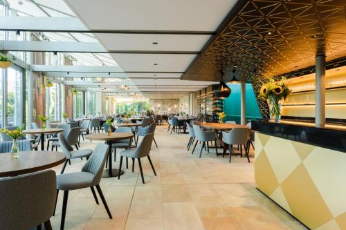 restauracja ze stołami, krzesłami i oknami w obiekcie Engimatt City & Garden Hotel w Zurychu