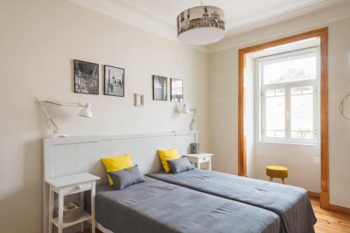 a bedroom with a large bed with yellow pillows at Alma de Santos Apartment in Lisbon