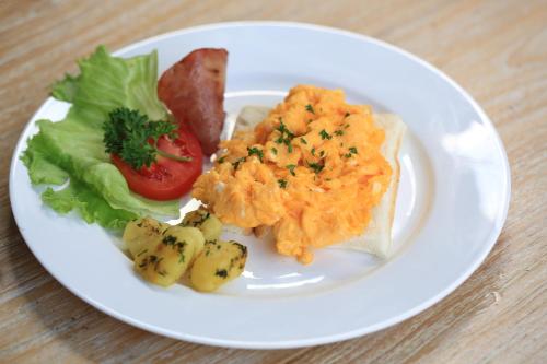 Un plato blanco con comida sobre una mesa. en Green Taman Ubud by Prasi, en Ubud