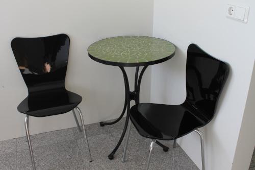 two black chairs and a table with a green table at Holssel road 864 in Myvatn