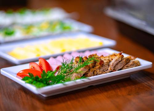 a plate of food with meat and vegetables on a table at Premium Pokoje & Bistro in Mielec