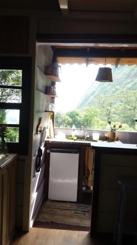 a kitchen with a sink and a window at Chales Bamboo Jungle in Petrópolis