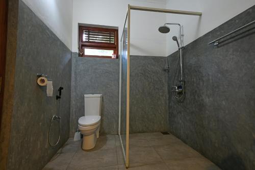 a bathroom with a shower and a toilet at Hettimulla River House in Bentota