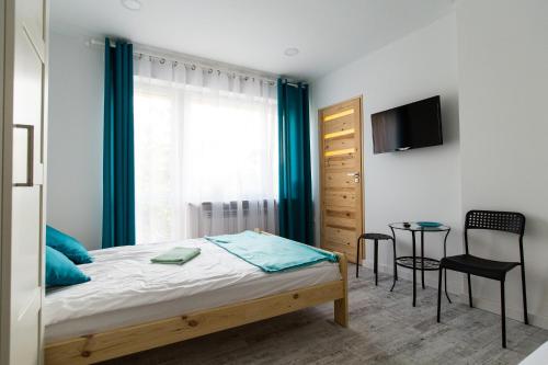 a bedroom with a bed and a tv and a table at Na Kwiatkowskiego in Sandomierz