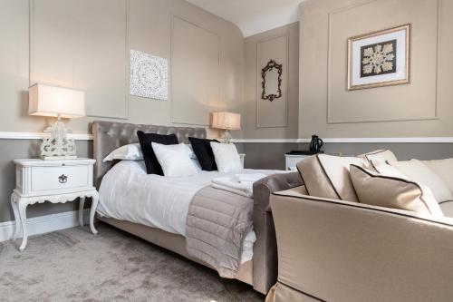 a bedroom with a large bed and a couch at Lansdowne House with Private Car Park in Llandudno