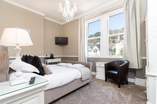 a bedroom with a bed and a desk and a chair at Lansdowne House with Private Car Park in Llandudno