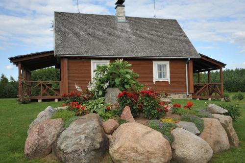 a house with a bunch of rocks in front of it at Country Houses Vidų Sodyba in Utena