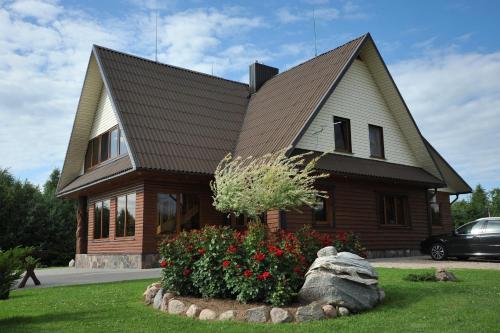 a house with a landscaping in front of it at Country Houses Vidų Sodyba in Utena