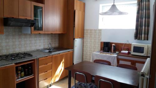a kitchen with wooden cabinets and a table with chairs at La Virgola Apartments in Brenzone sul Garda