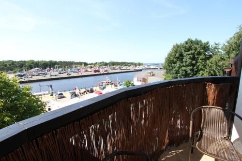 a balcony with a bench and a view of a river at Fisherman's House in Ustka