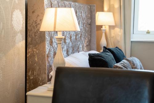 a bedroom with a bed with two lamps on it at Lansdowne House with Private Car Park in Llandudno