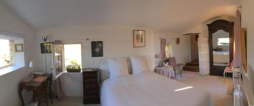 ein Schlafzimmer mit einem großen weißen Bett in einem Zimmer in der Unterkunft B&B Chambre de Julie Le Jardin in Vaison-la-Romaine