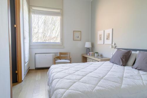 a bedroom with a large white bed and a window at Wonderful Brera flat in Milan