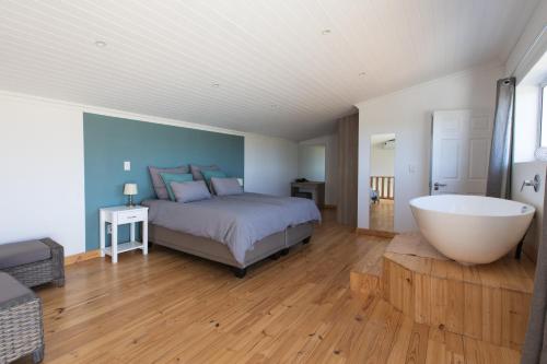 a bedroom with a bed and a bathtub and a bed and a bathroom at Sweetwater Guesthouse in Wellington