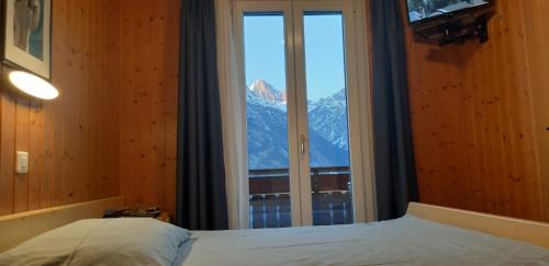 a bedroom with a window with a view of a mountain at B&B Eischoll in Eischoll