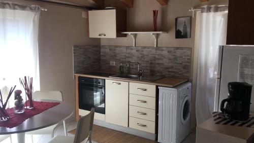 a kitchen with a table and a sink and a dishwasher at Mansarda 5 terre in Monterosso al Mare