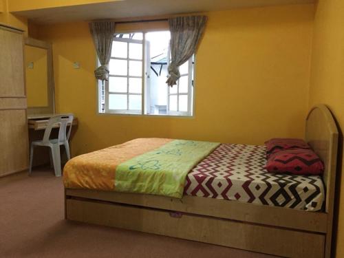 a bedroom with a bed with a window and a kitchen at Desa Anthurium in Cameron Highlands