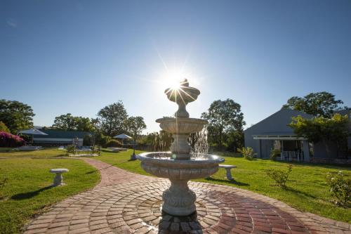 a fountain in a park with the sun behind it at Sweetwater Guesthouse in Wellington