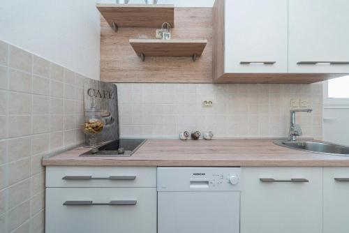 a kitchen with white cabinets and a sink at Apartment Maja in Novalja in Novalja
