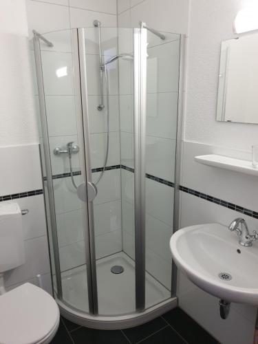 a bathroom with a shower and a toilet and a sink at Kirchberg Hotel garni in Saarbrücken