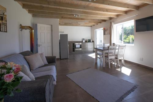 a living room with a couch and a table with chairs at Sweetwater Guesthouse in Wellington