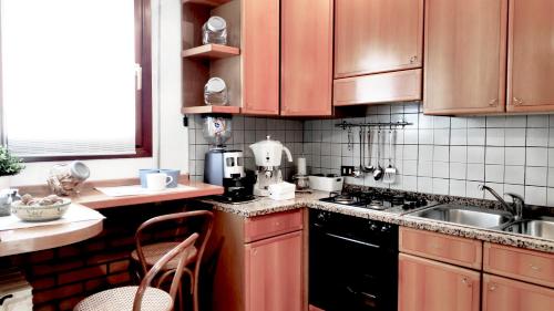 La cuisine est équipée de placards en bois et d'un four avec plaques de cuisson. dans l'établissement Casa Lory, à Mestre