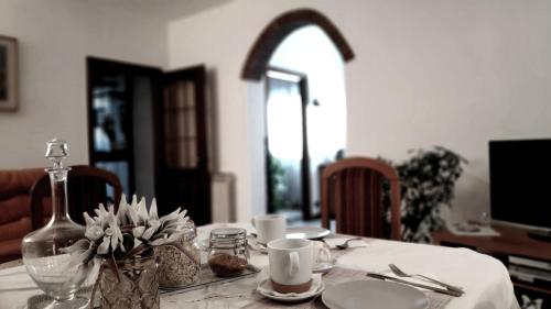 une table à manger avec un tissu de table blanc et un vase avec des fleurs dans l'établissement Casa Lory, à Mestre