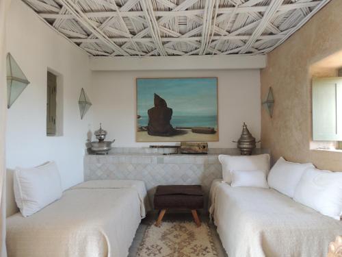 two beds in a room with white walls at Dar al Hossoun in Taroudant