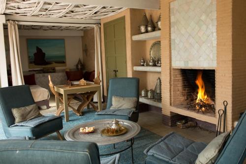 a living room with chairs and a fireplace at Dar al Hossoun in Taroudant