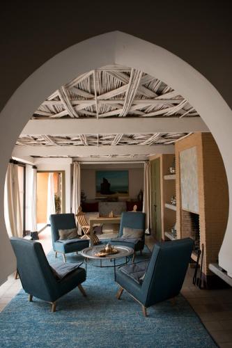 a living room with chairs and a table and a couch at Dar al Hossoun in Taroudant