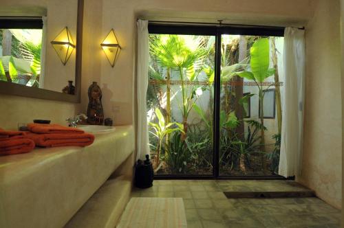 a bathroom with a tub and a sink and a window at Dar al Hossoun in Taroudant