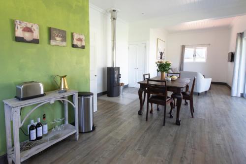 a living room with a table and a dining room at Sweetwater Guesthouse in Wellington