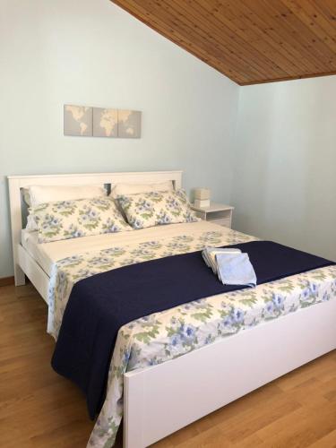 a bedroom with a bed with a blue and white comforter at B&B Porta Girone in Civitanova Alta