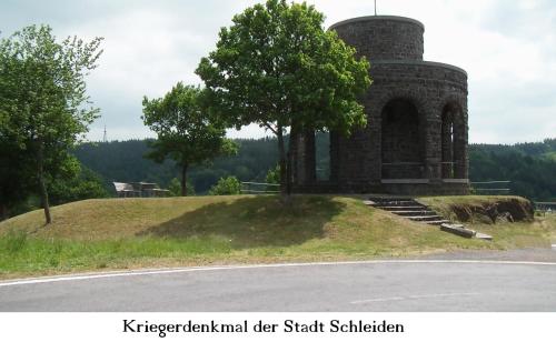 a building on top of a hill with a tree at Ferienwohnung Gross B in Schleiden