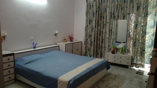 een slaapkamer met een bed en een spiegel bij Aadhaar in Lucknow
