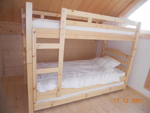 a bedroom with two bunk beds in a cabin at Bungalow du Lac in Froid-Chapelle