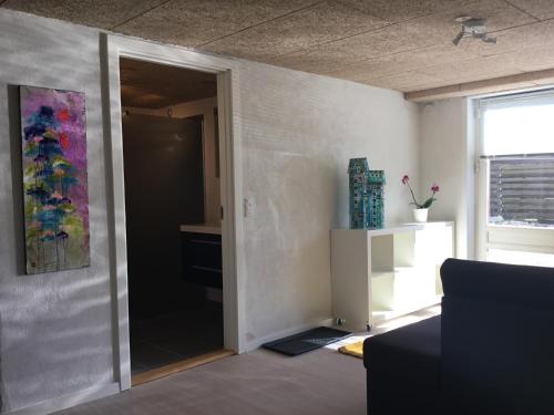 ein Wohnzimmer mit einer Tür in ein Zimmer mit einem Gemälde in der Unterkunft Århus nord bed and breakfast in Hinnerup