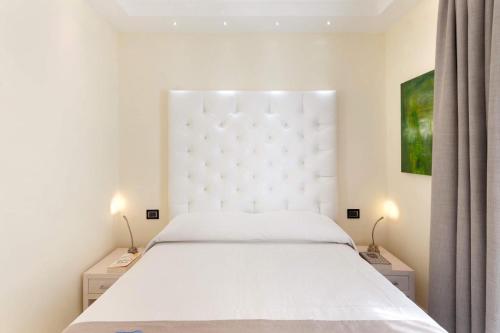 a bedroom with a white bed and two night stands at Palazzo Tritone & Abagnale in Sorrento