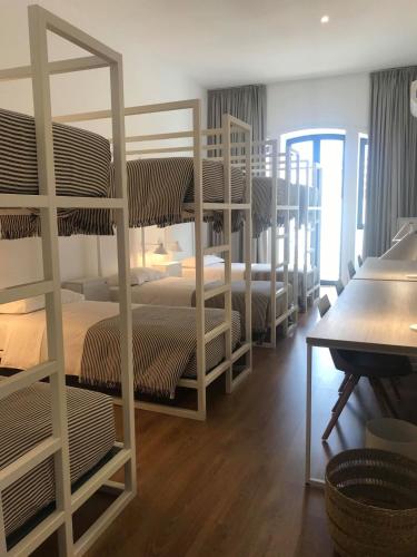 a room with several bunk beds in a room at HOSTEL ALAMEDA EXCLUSIVE HOUSE in Faro