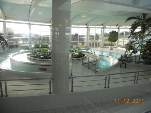 duży budynek z basenem w centrum handlowym w obiekcie Bungalow du Lac w mieście Froid-Chapelle