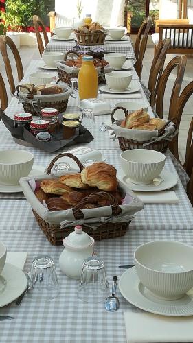 una mesa larga con platos y tazones de comida en La ferme du guindal en Marquise