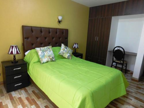 a bedroom with a green bed with two pillows at Reggio Green Hotel in Abancay