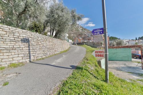 a street sign on the side of a brick wall at Apartments Marija in Sveti Stefan