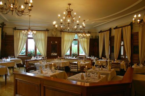 a dining room with white tables and chairs and a chandelier at Posthotel Rössle in Gaschurn