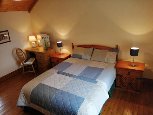 a bedroom with a bed and a desk with two lamps at Tig Rua in Killarney