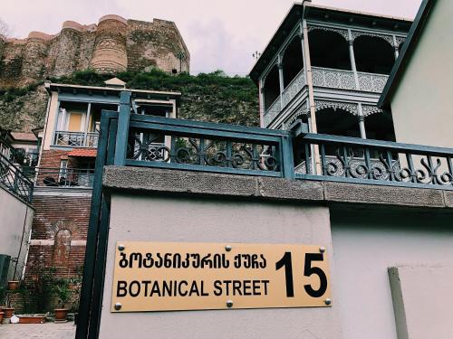 a building with a balcony with a sign on it at Apartment Botanikuri 15 in Tbilisi City