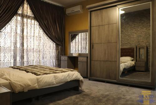 ベイルートにあるGrand Suites Hotelのベッドと大きな鏡のある寝室
