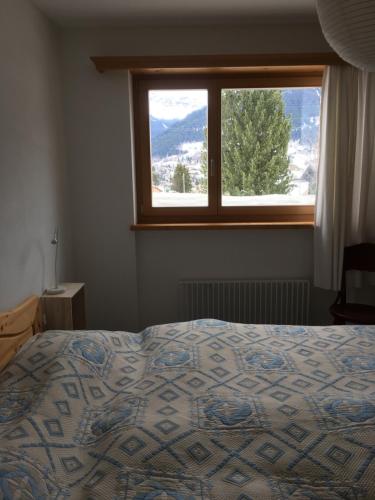 een slaapkamer met een bed en een groot raam bij Haus am Golfplatz in Selfranga