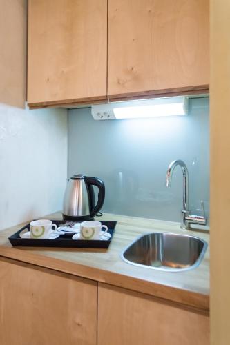 a kitchen counter with a sink and a tea kettle at Polixeny's Suites in Chania Town